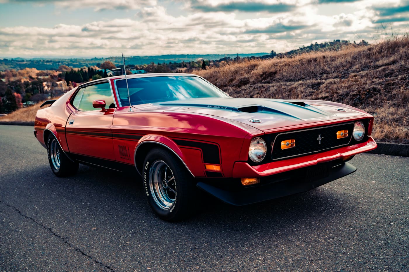 Classic red muscle car parked on a scenic road