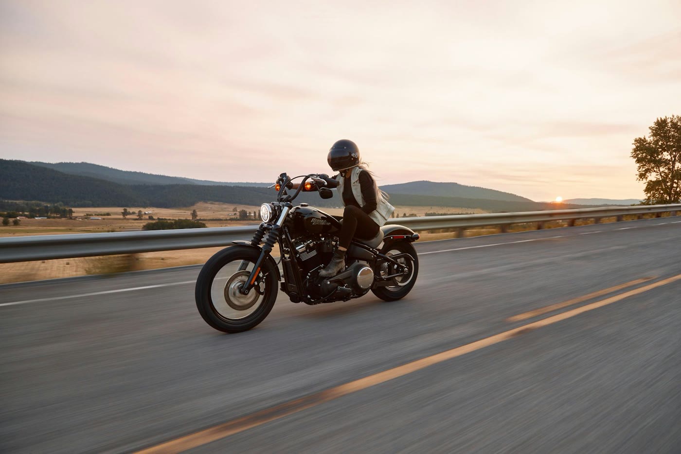Cruiser motorcycle on an open highway at sunset